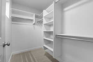 Walk in closet featuring light colored carpet