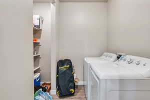 Laundry room featuring washing machine and dryer and hardwood / wood-style flooring