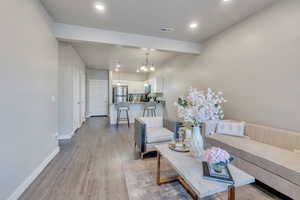 Living room featuring an inviting chandelier and light hardwood / wood-style floors