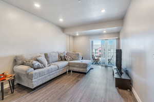 Living room featuring wood-type flooring and a textured ceiling