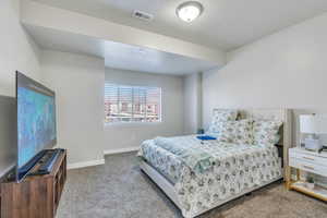 Carpeted bedroom with a textured ceiling