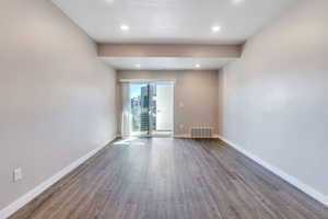 Spare room featuring a textured ceiling and wood-type flooring