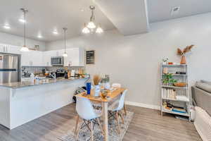 Kitchen with appliances with stainless steel finishes, kitchen peninsula, and white cabinetry