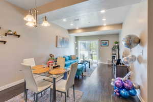 Dining space featuring a textured ceiling, an inviting chandelier, and dark hardwood / wood-style floors