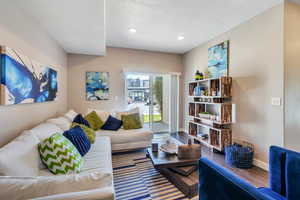 Living room with a textured ceiling and hardwood / wood-style floors