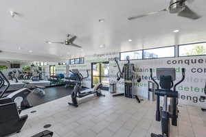 Workout area featuring ceiling fan and a textured ceiling