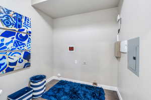 Laundry area featuring hookup for a washing machine, hardwood / wood-style floors, hookup for an electric dryer, and electric panel