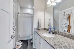 Full bathroom with shower / bath combo, hardwood / wood-style floors, vanity, and toilet