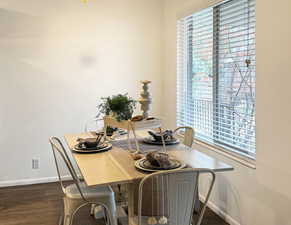 Dining space with dark wood-type flooring and a healthy amount of sunlight