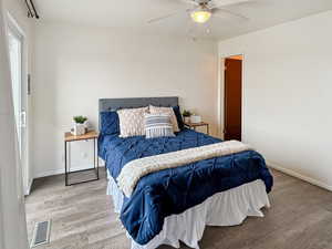 Bedroom with hardwood / wood-style floors and ceiling fan