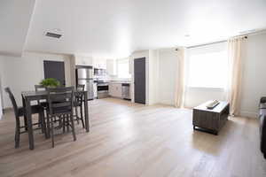 Dining room with light hardwood / wood-style flooring, a healthy amount of sunlight, and sink