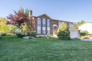 View of front of house with a garage and a front yard