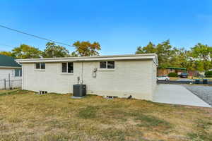 Rear view of property with a yard, central AC, and a patio area