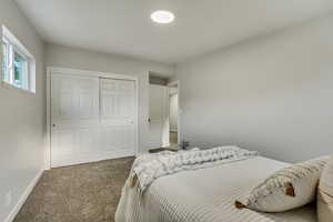 Bedroom featuring a closet and dark colored carpet