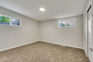 Empty room featuring carpet floors and a healthy amount of sunlight