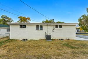 Rear view of house with a yard and central AC