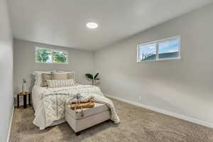 Carpeted bedroom with multiple windows