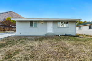 View of front of property featuring a front lawn and a mountain view