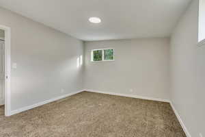 Unfurnished room featuring lofted ceiling and carpet floors