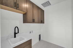 Laundry room featuring electric dryer hookup, sink, cabinets, and washer hookup