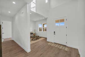 Entryway with hardwood / wood-style floors and a high ceiling