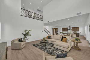 Living room featuring light wood-type flooring and a high ceiling