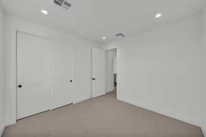 Unfurnished bedroom with light colored carpet and a closet