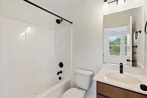 Full bathroom featuring vanity, toilet, and shower / tub combination