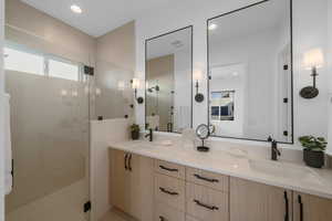 Bathroom featuring a shower with door and vanity