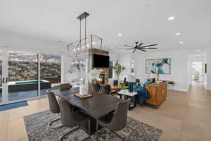 Dining room with light tile patterned flooring, a healthy amount of sunlight, and a stone fireplace