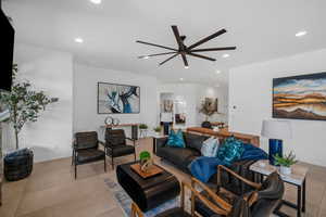 Living room featuring light tile patterned floors and ceiling fan