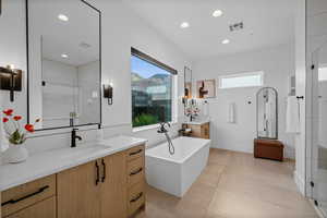 Bathroom featuring vanity, tile patterned floors, and shower with separate bathtub