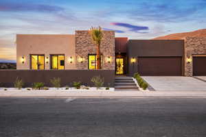 Pueblo revival-style home featuring a garage