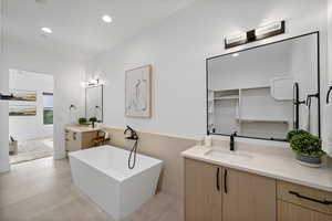 Bathroom with vanity, tile walls, and a washtub