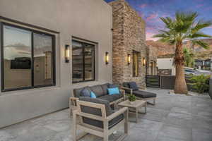 Patio terrace at dusk featuring an outdoor hangout area