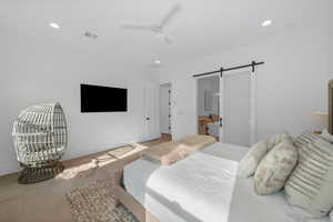 Bedroom featuring a barn door and ceiling fan