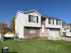 Raised ranch with a garage and a front lawn