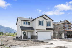 View of front of house featuring a garage, cooling unit, and a mountain view