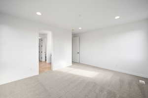 Primary bedroom with light carpet