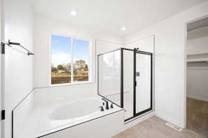 Bathroom featuring tile patterned flooring and shower with separate bathtub