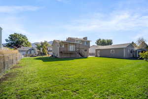 Back of property featuring a deck and a lawn