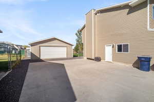 View of property exterior featuring attached garage and an detached shop