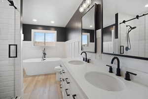 Full bathroom featuring wood-type flooring, toilet, vanity, and separate shower and soaker tub