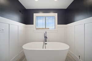 Bathroom with a tub and hardwood / wood-style flooring