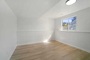 Empty room featuring a textured ceiling and light hardwood / wood-style flooring