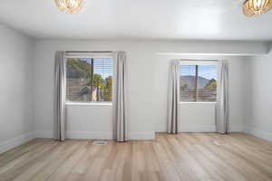 Empty room with a healthy amount of sunlight and light hardwood / wood-style floors