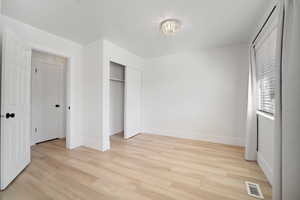 Unfurnished bedroom with light wood-type flooring and a closet