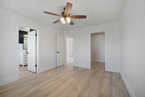 Unfurnished bedroom featuring ceiling fan, ensuite bath, and light hardwood / wood-style floors