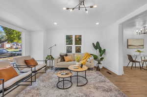 Living room featuring plenty of natural light, light hardwood / wood-style floors, and an inviting chandelier