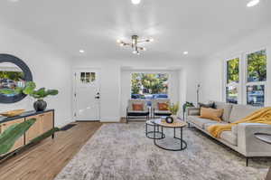 Living room with a notable chandelier and light wood-type flooring